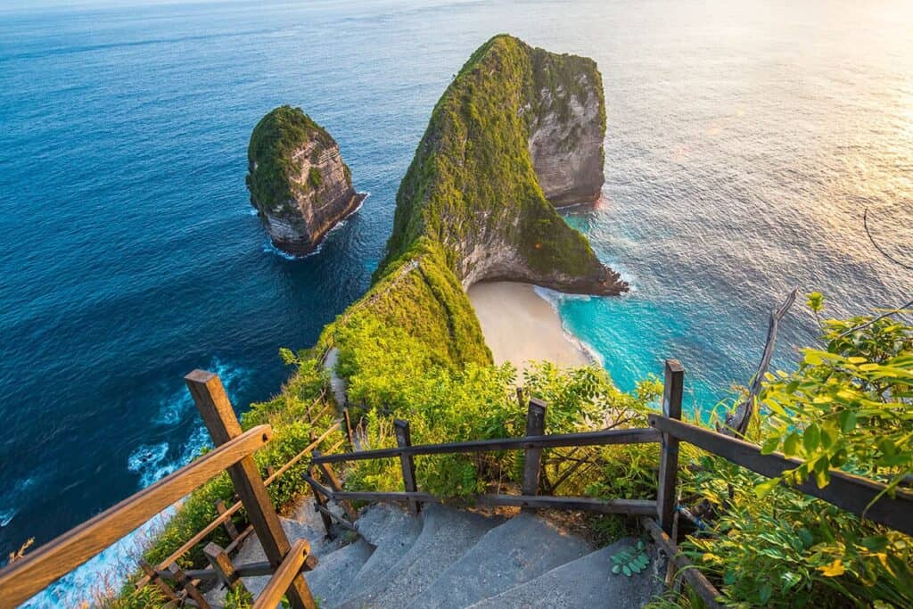 Stairs leading down to Kelingking Beach with cliffs and turquoise ocean in the background.