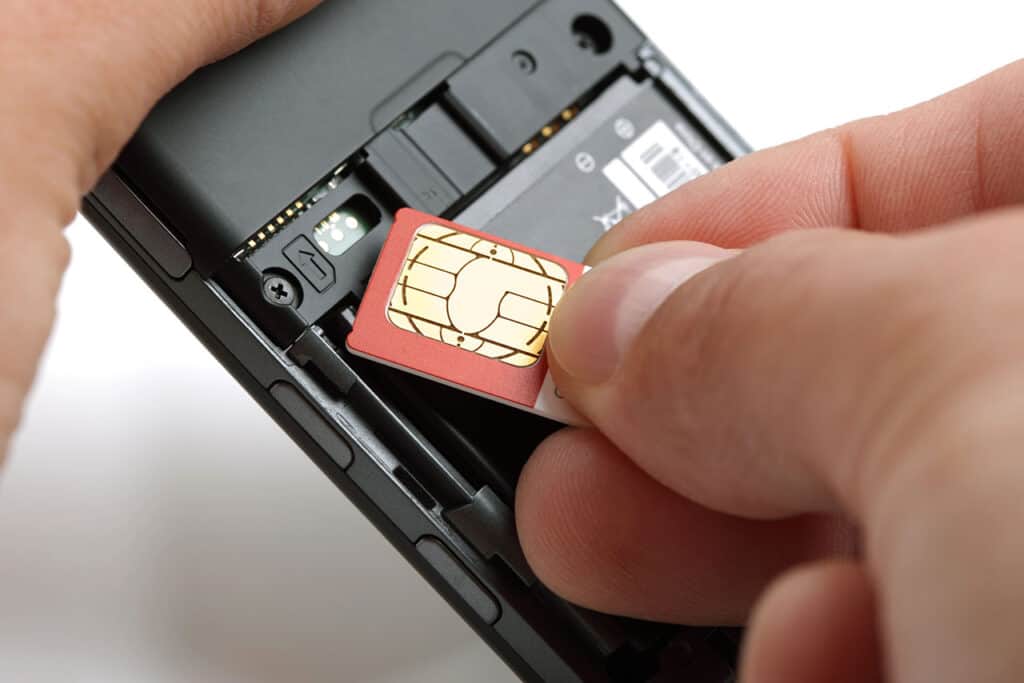 A person inserting a SIM card into a mobile phone.